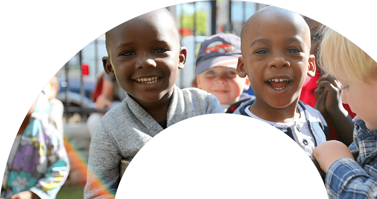 Smiling children at a community event supporting The Genesis Fund.
