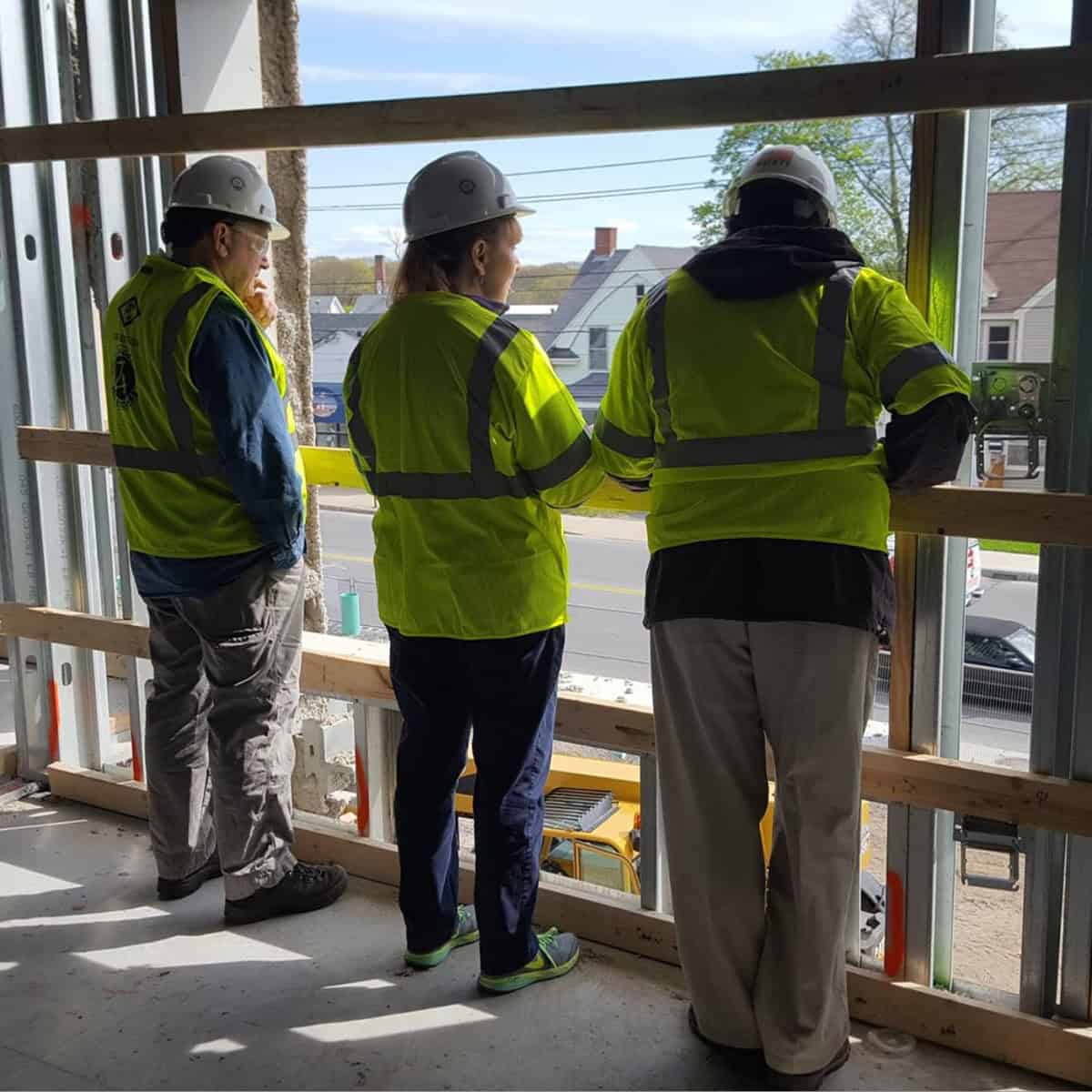 Engineers inspecting a building site with safety gear and helmets.