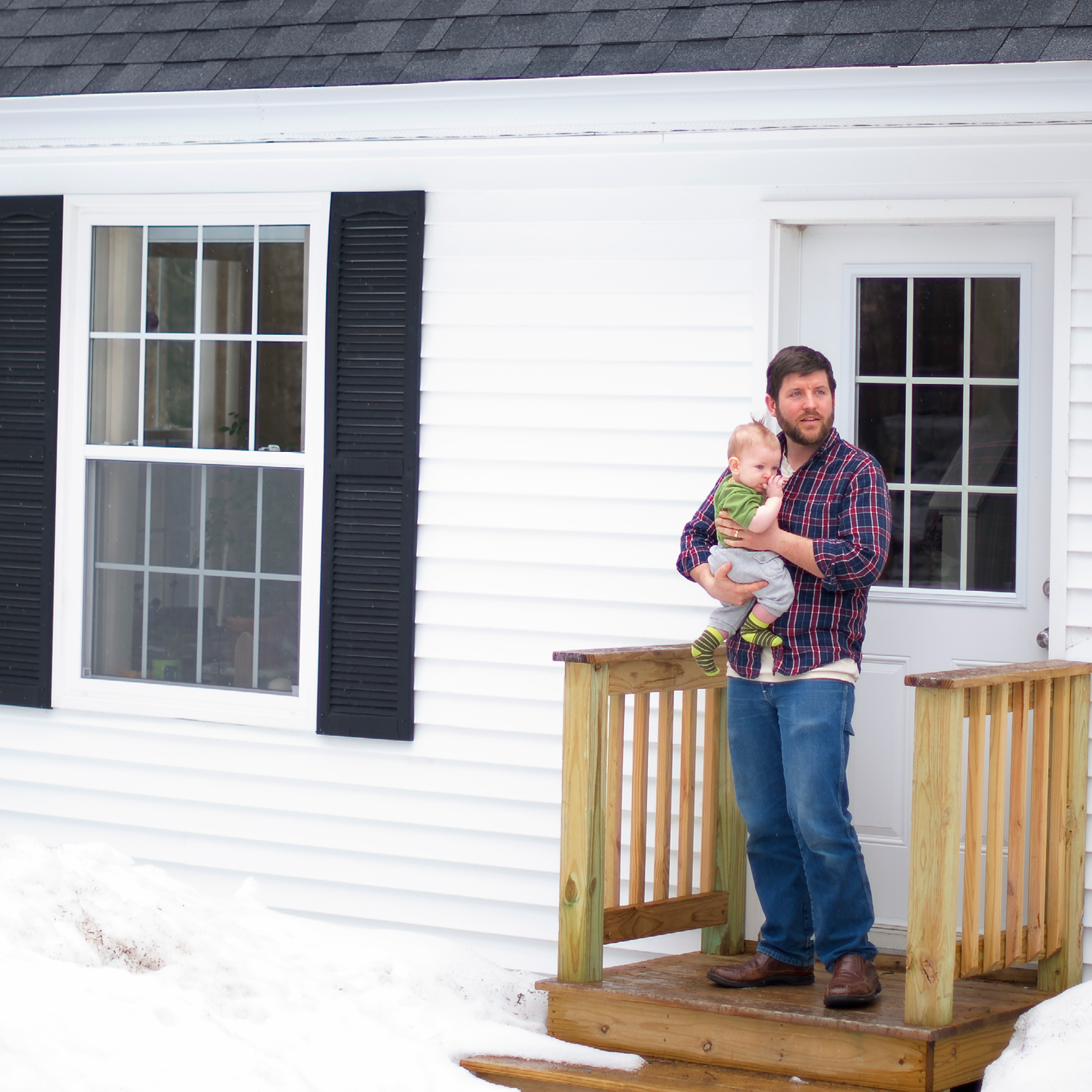 A father and his young child stand proudly on the front steps of their newly constructed home on the island of Islesboro, Maine, built as part of a multi-year Genesis Fund initiative to help Maine island communities develop affordable year-round housing.