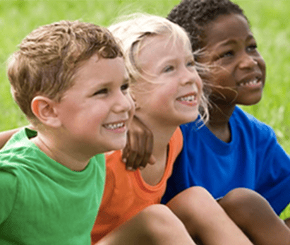 Diverse children smiling outdoors, representing community and hope.