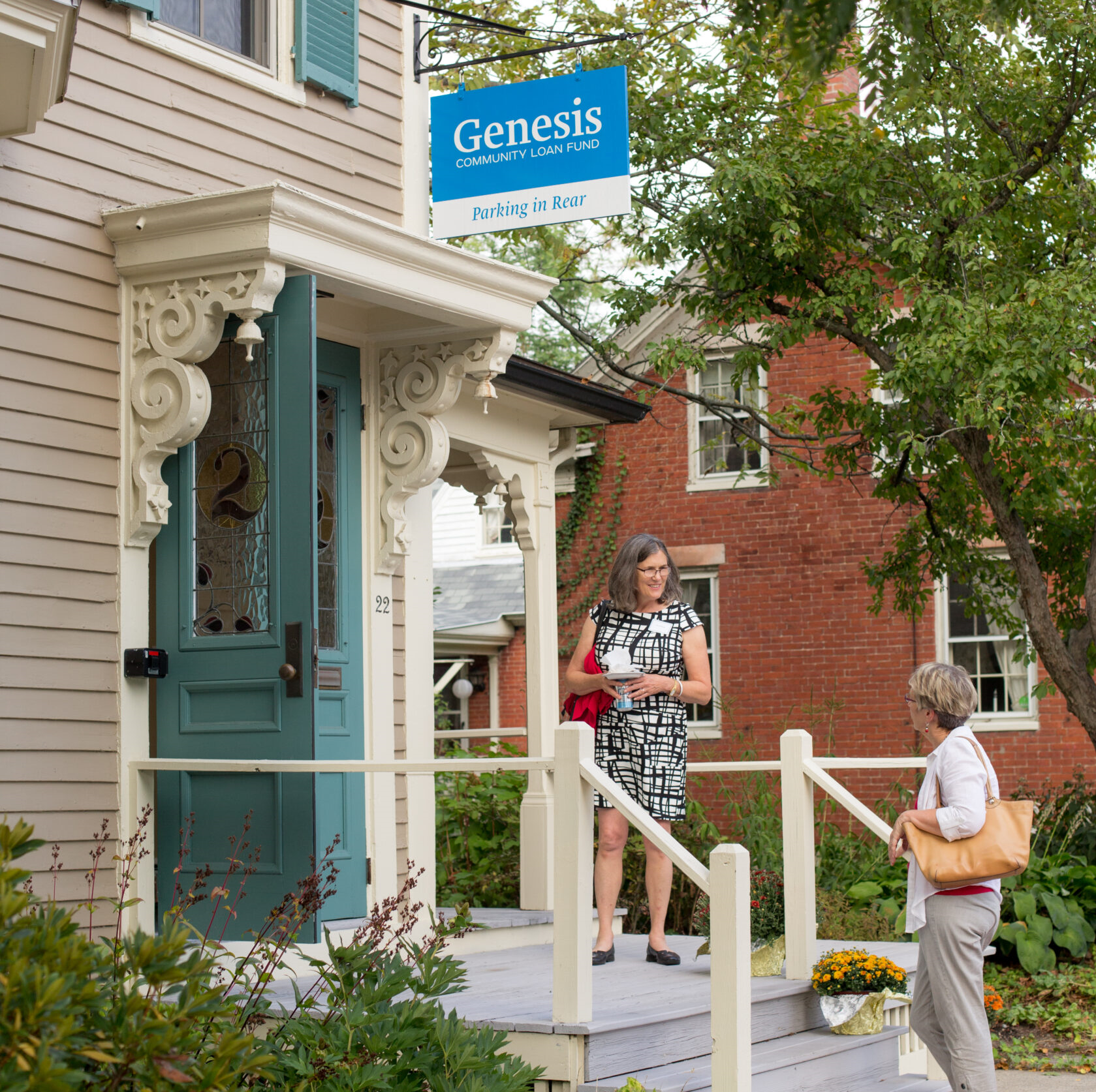 A person greets a visitor from the open doorway to the Genesis Fund's office at 22 Lincoln Street in Brunswick.