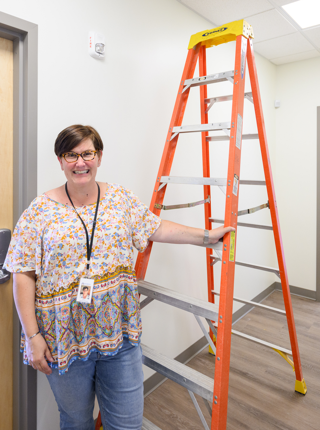 A woman stands alongside a ladder inside a new community medical clinic that Genesis Fund helped to finance.
