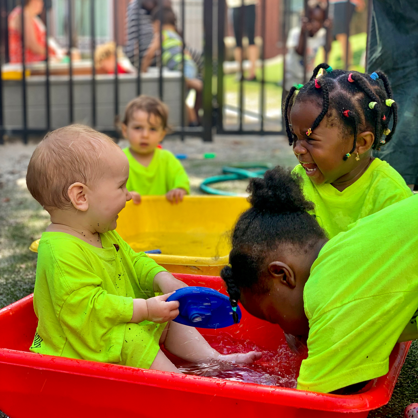 A group of young preschool children laugh with each other as they play in baby pools at Youth and Family Outreach in Portland, Maine.