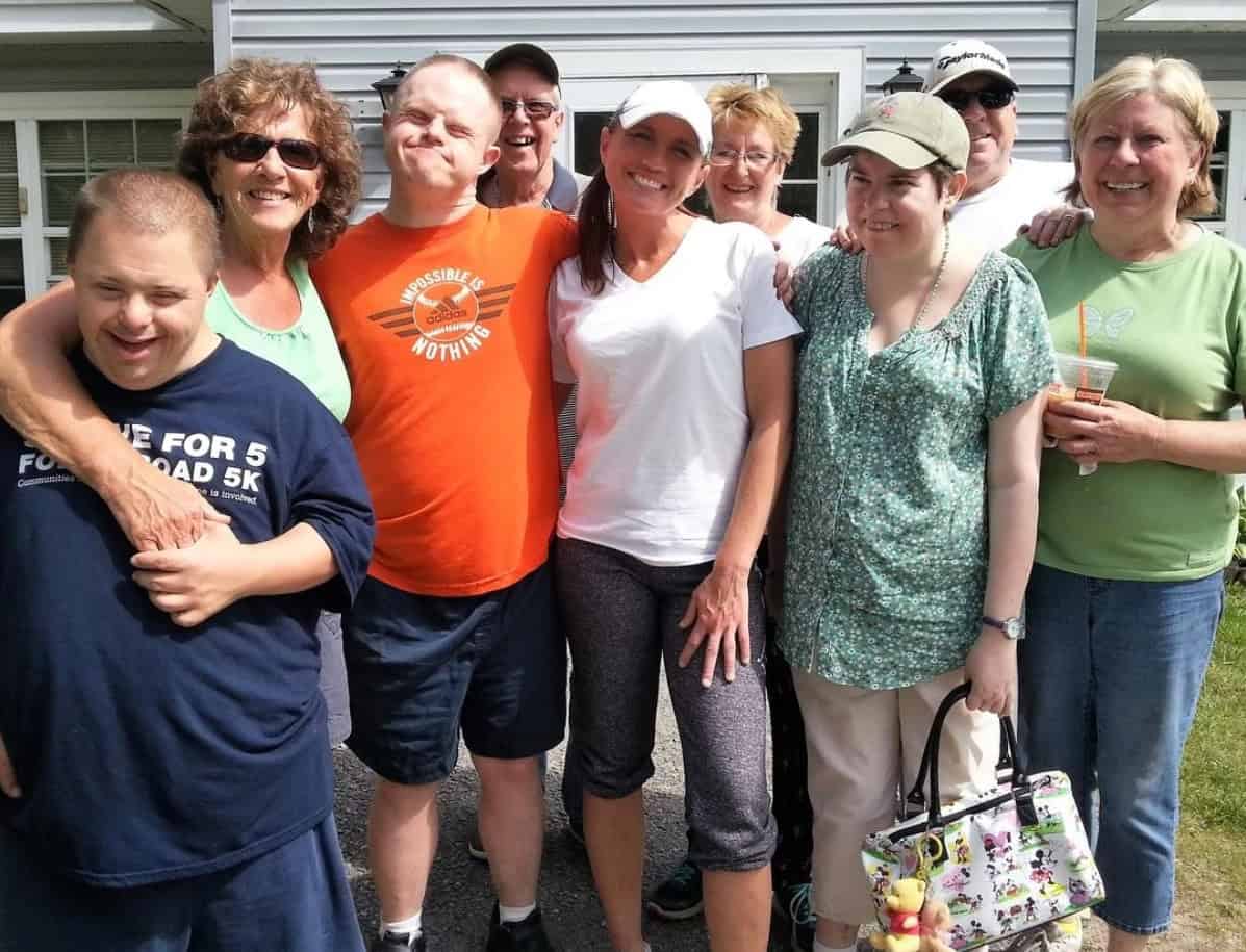 Group of diverse people smiling outdoors at The Genesis Fund event.