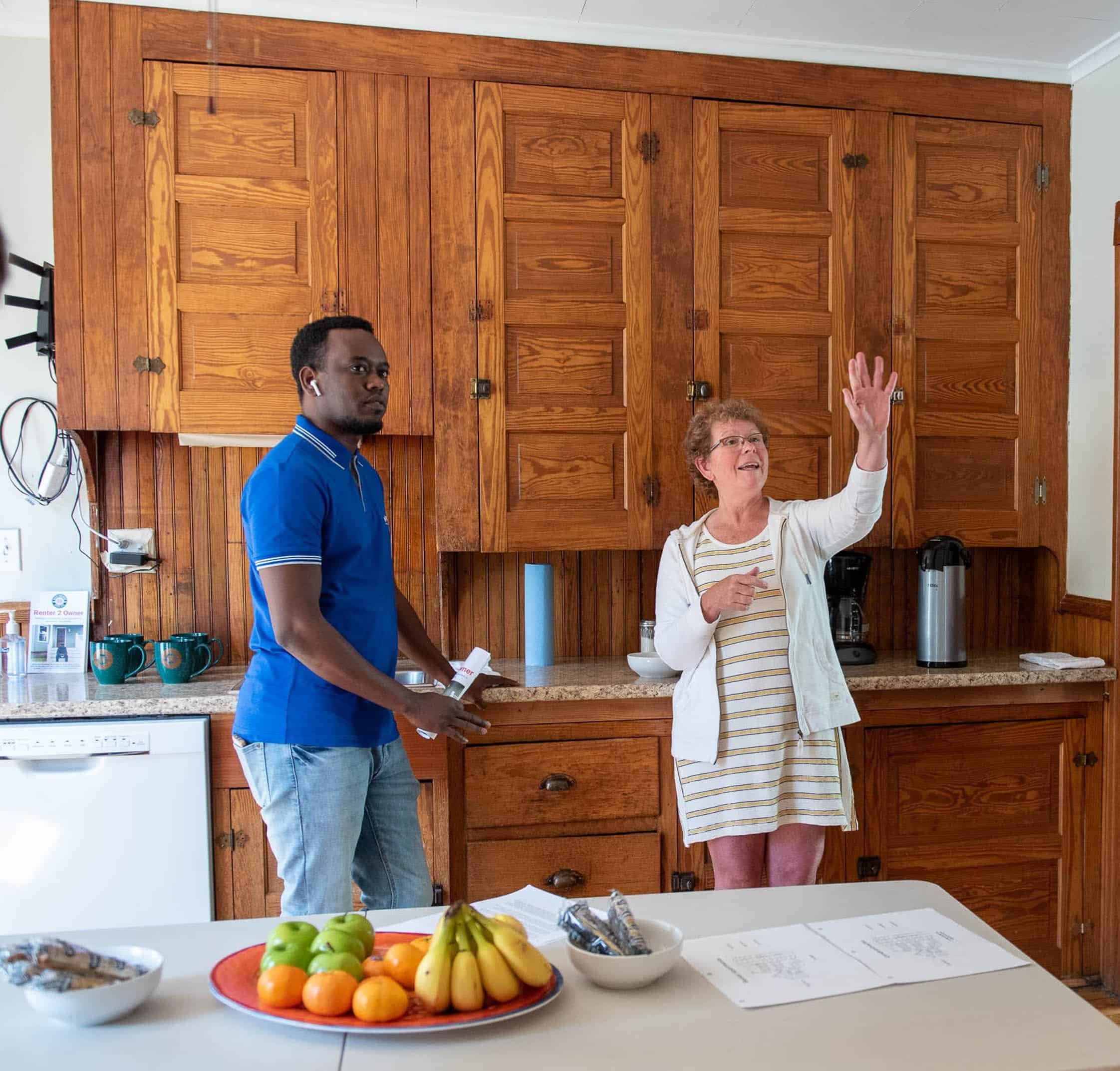 Diverse group in kitchen discussing and sharing ideas.