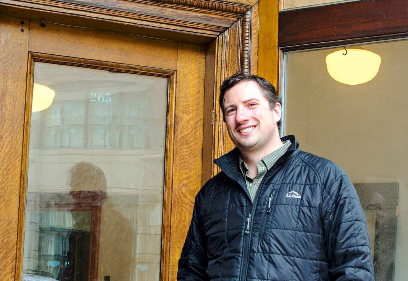 Smiling man outside The Genesis Fund office building.