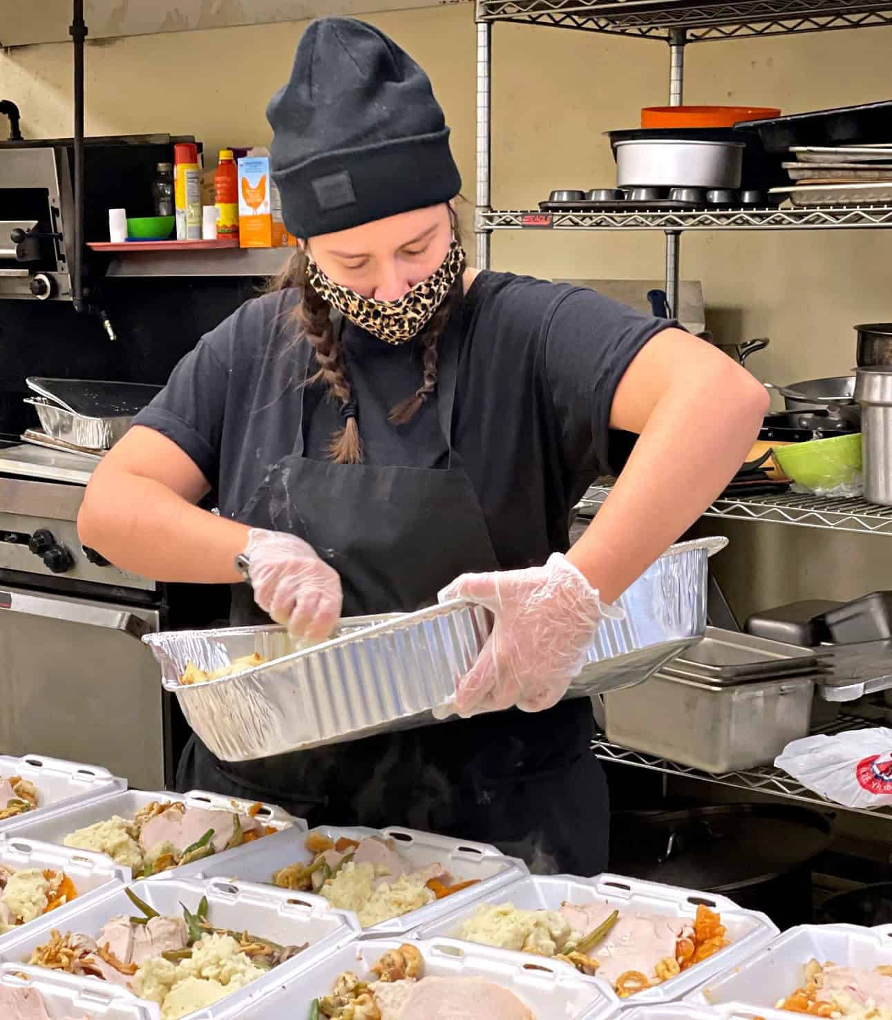 Volunteer preparing meals at The Genesis Fund kitchen.