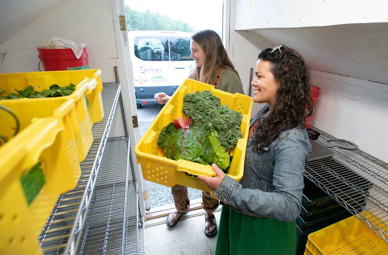 Women handling fresh vegetables in a community food pantry.