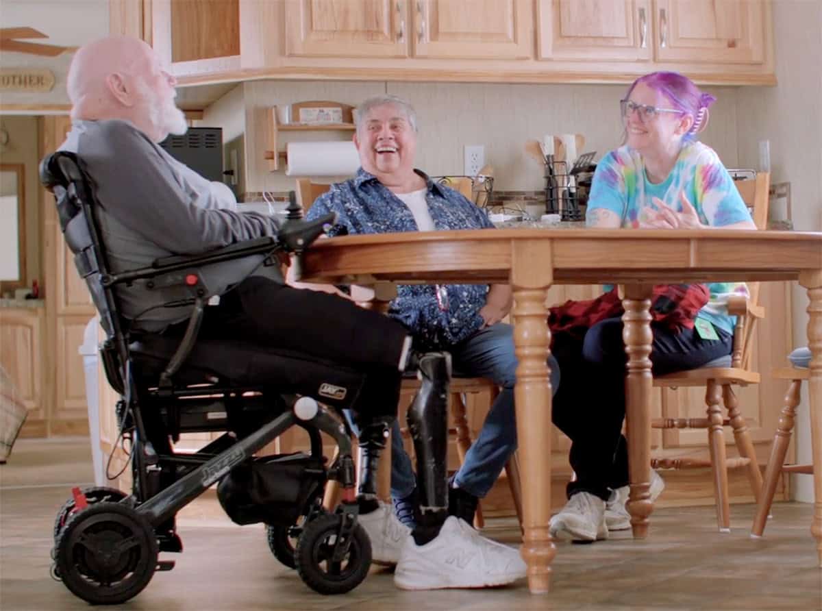 Diverse group of people enjoying a meal together in a cozy kitchen.