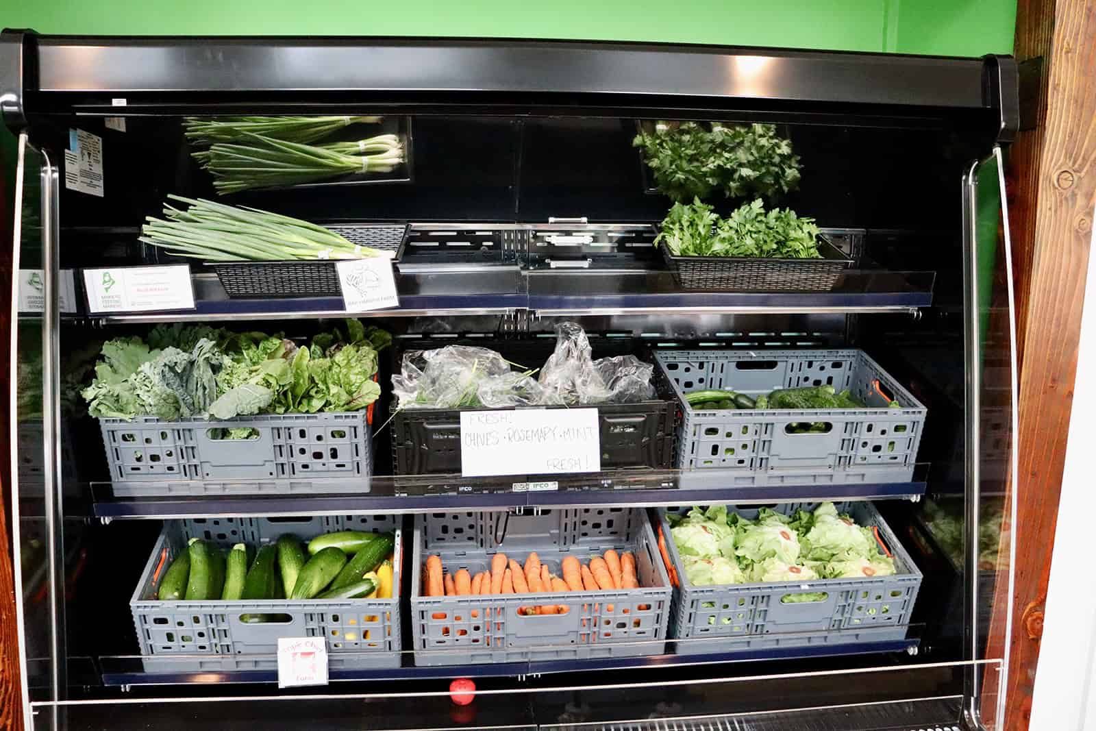 Fresh vegetables in a refrigerated display case at Genesis Fund.
